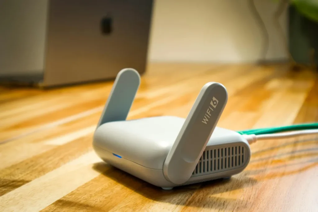 Router WiFi modern dengan antena di atas meja kayu untuk pengaturan jaringan rumah